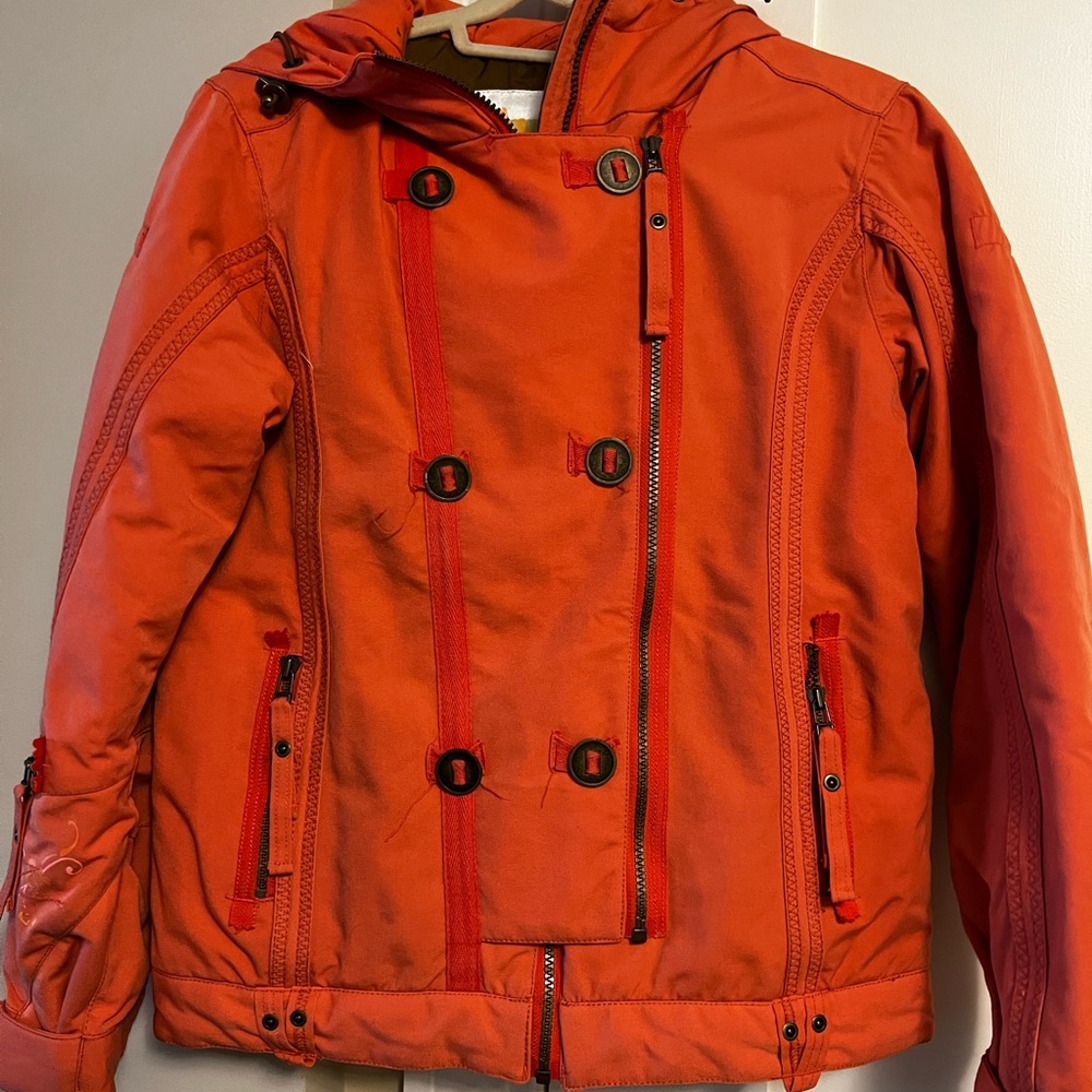 Obermeyer ski jacket in orange with brown lining. Lots of pockets, zipper front.